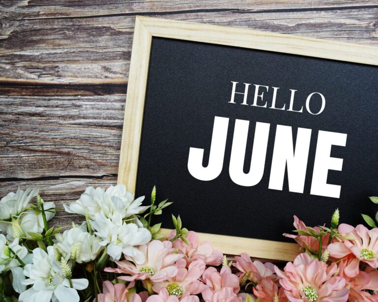 Hello June on a black sign with flowers witch's almanac