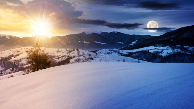 he sun and full moon shining together over snowy mountain hills — illustrating the balance of light and dark during the Full Cold Moon and Winter Solstice for witches and spiritual seekers.